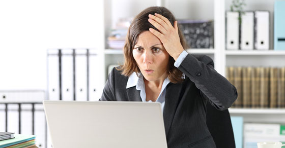 woman looking at computer with surprised expression