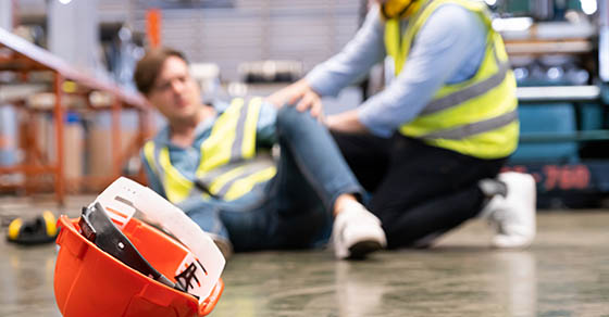 construction worker helping coworker who fell on the ground