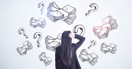 image of a dark haired women looking at pictures of stacks of money and question marks