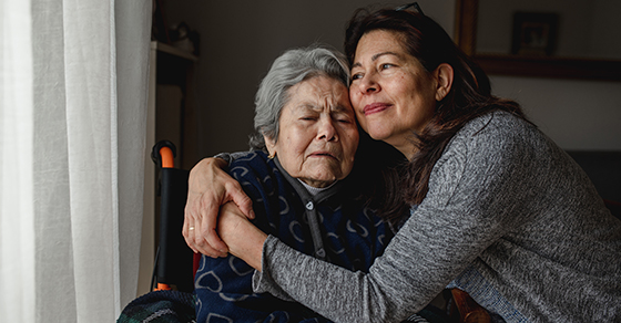 middle age woman hugging elderly woman