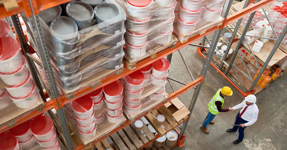 two men shaking hands under storage racks