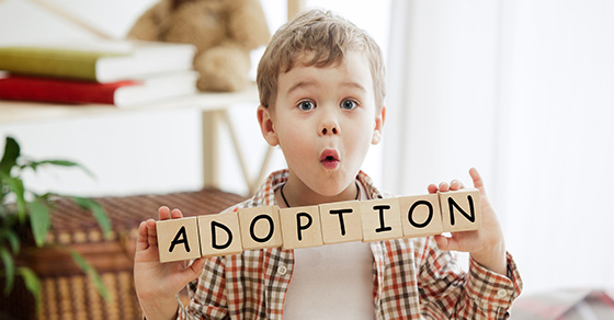 boy holding blocks that say adoption