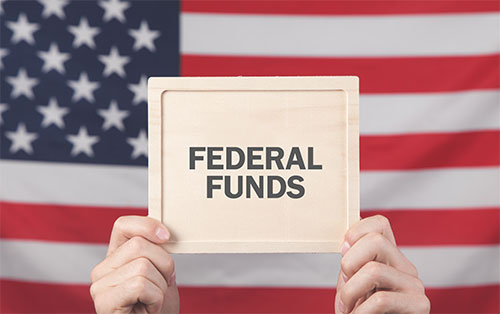 image of hands holding sign that reads federal funds