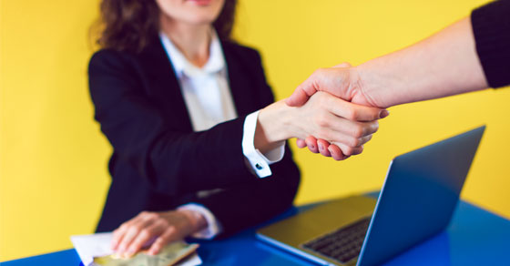 image of businesswoman reaching hand across desk