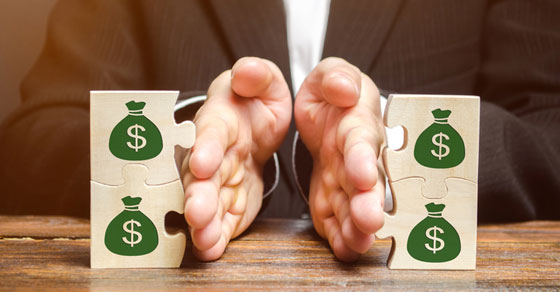 image of hands separating puzzle pieces with money sign on pieces