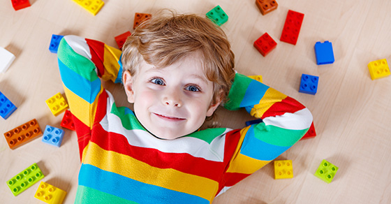 child laying on floor with toys