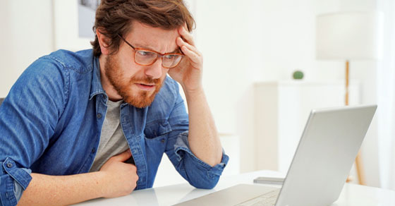 man confused looking at laptop