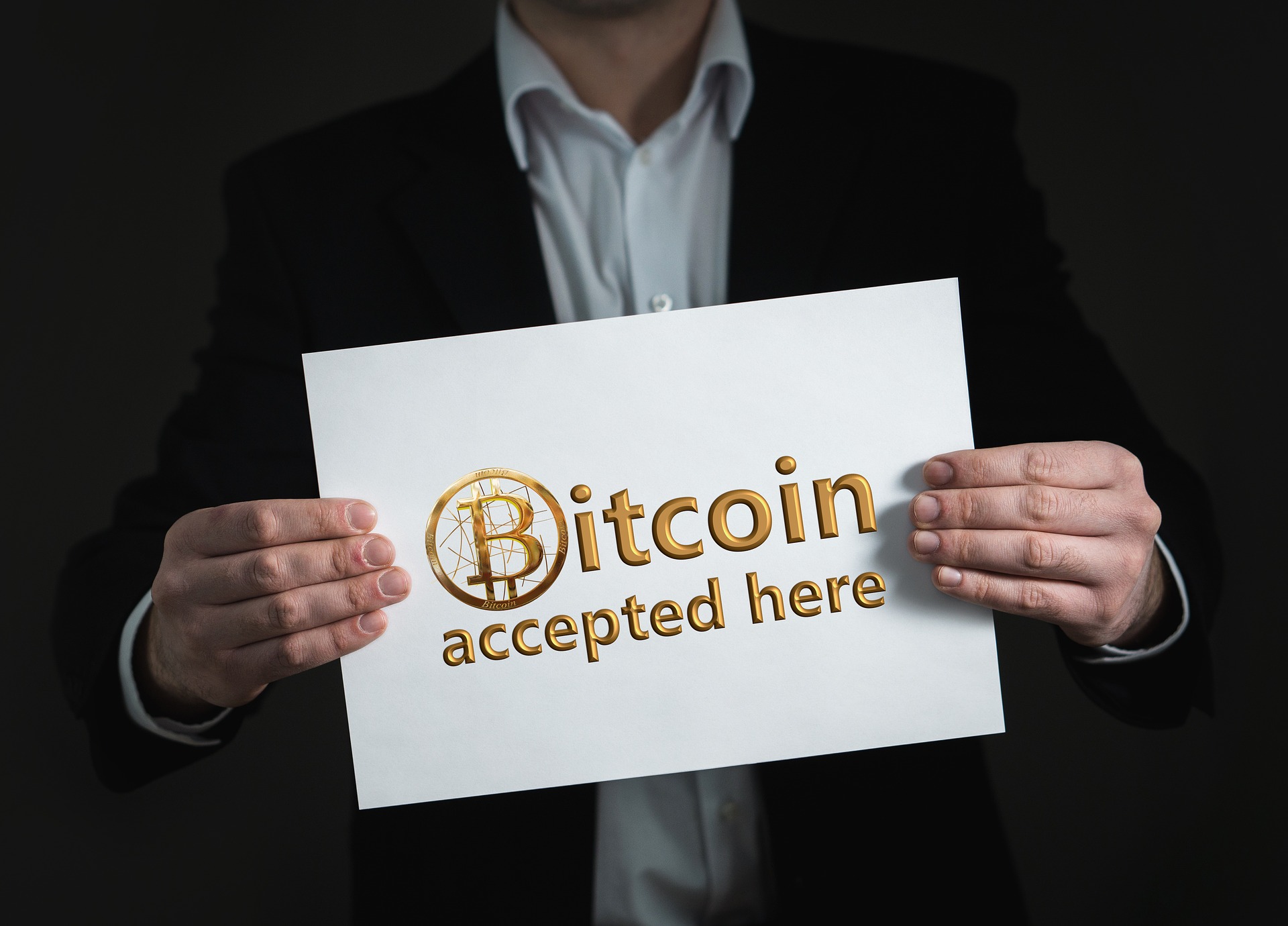 man holding bitcoin sign