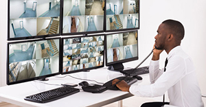 image of man sitting at computer screens